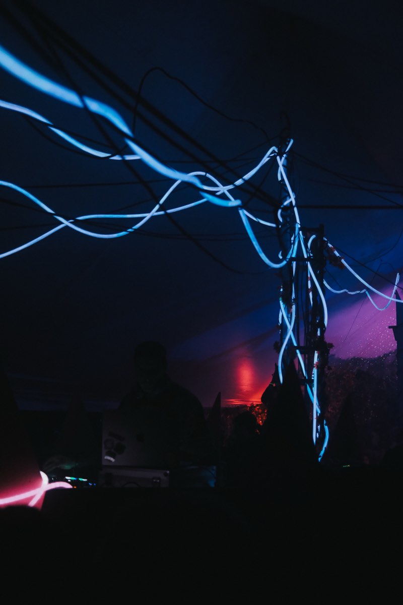 Blue illuminated tubes extending across the tent from the central structure